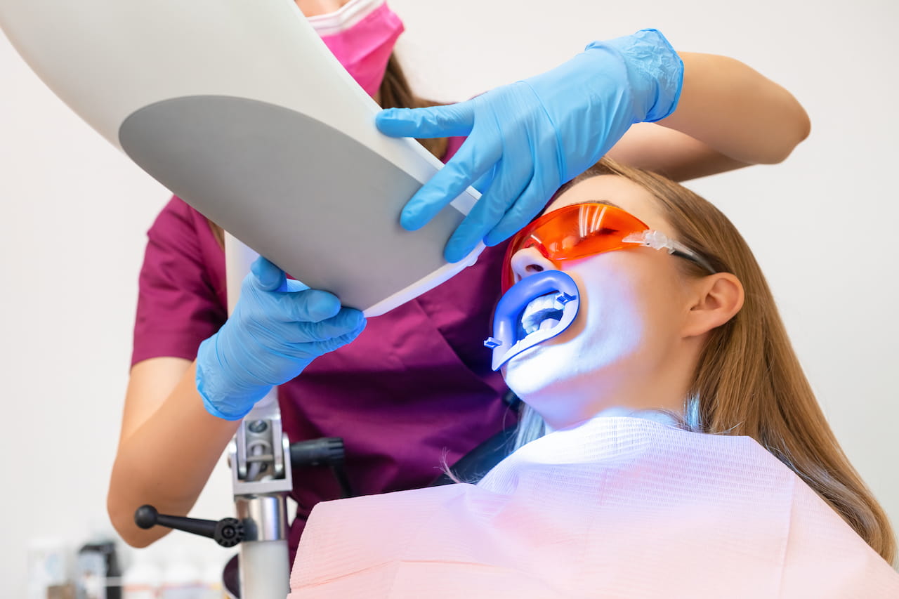 donna effettua sbiancamento dentale dal dentista