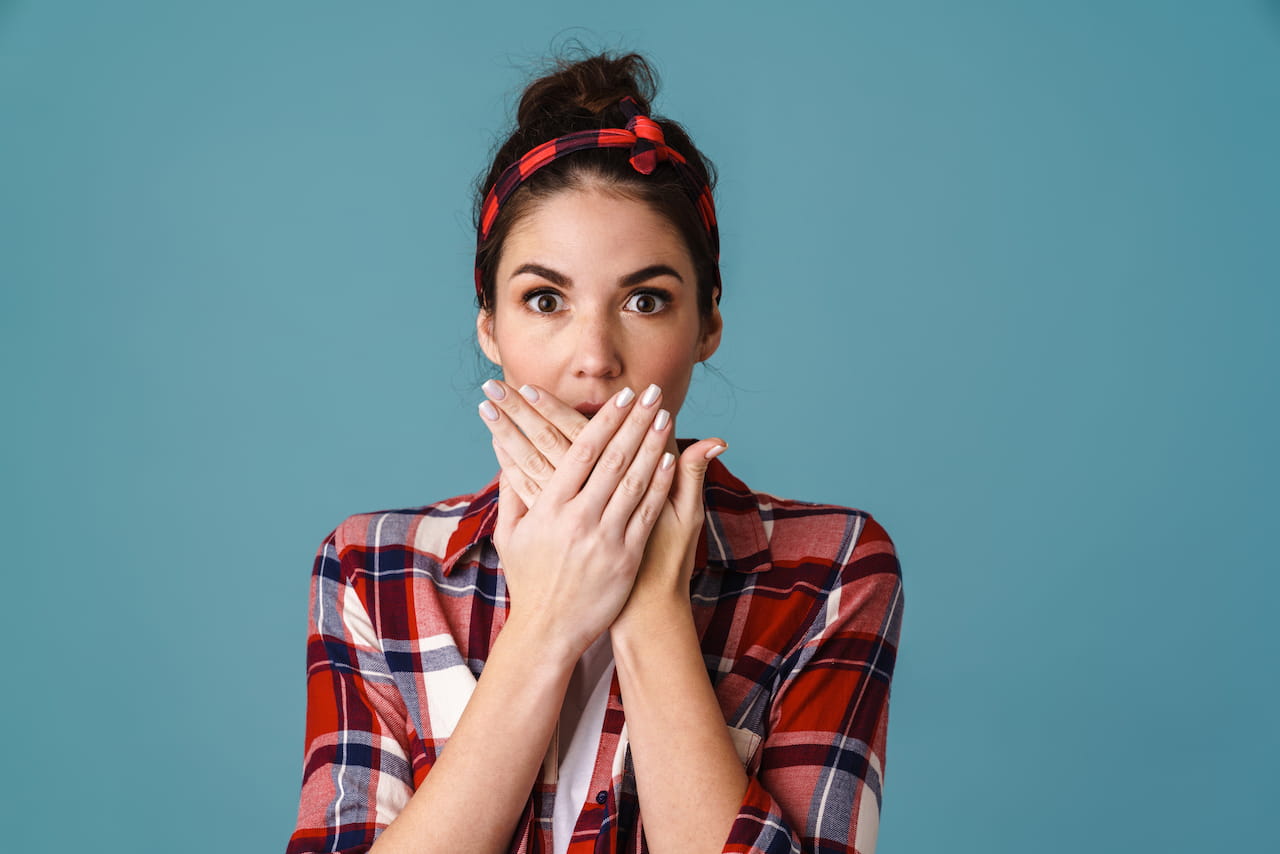 ragazza si copre la bocca per non far vedere macchie bianche sui denti