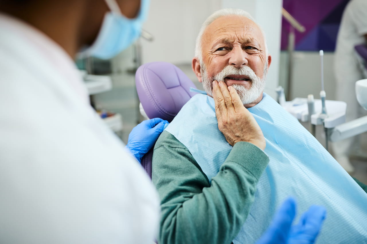 uomo adulto dal dentista con dolore all’impianto dentale