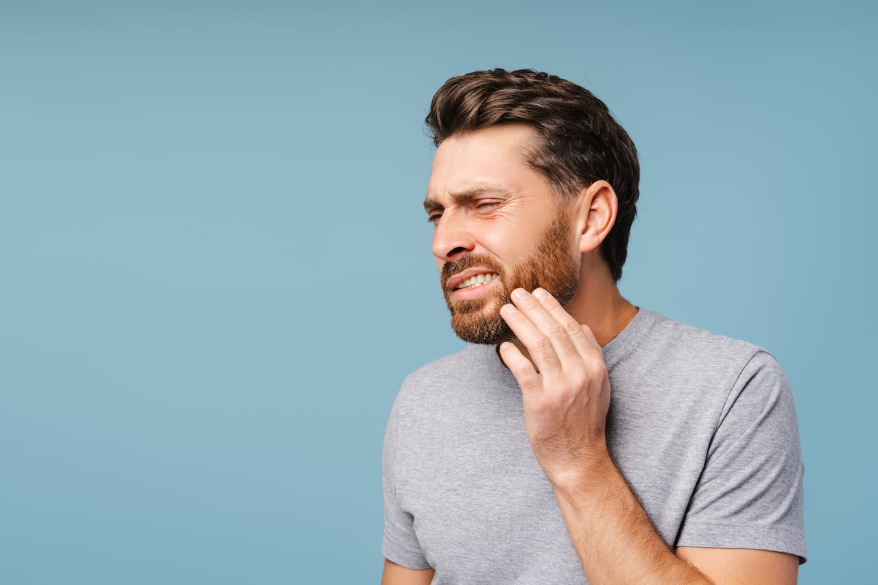 uomo con dente rotto uomo adulto si tocca la guancia per dolore da dente rotto